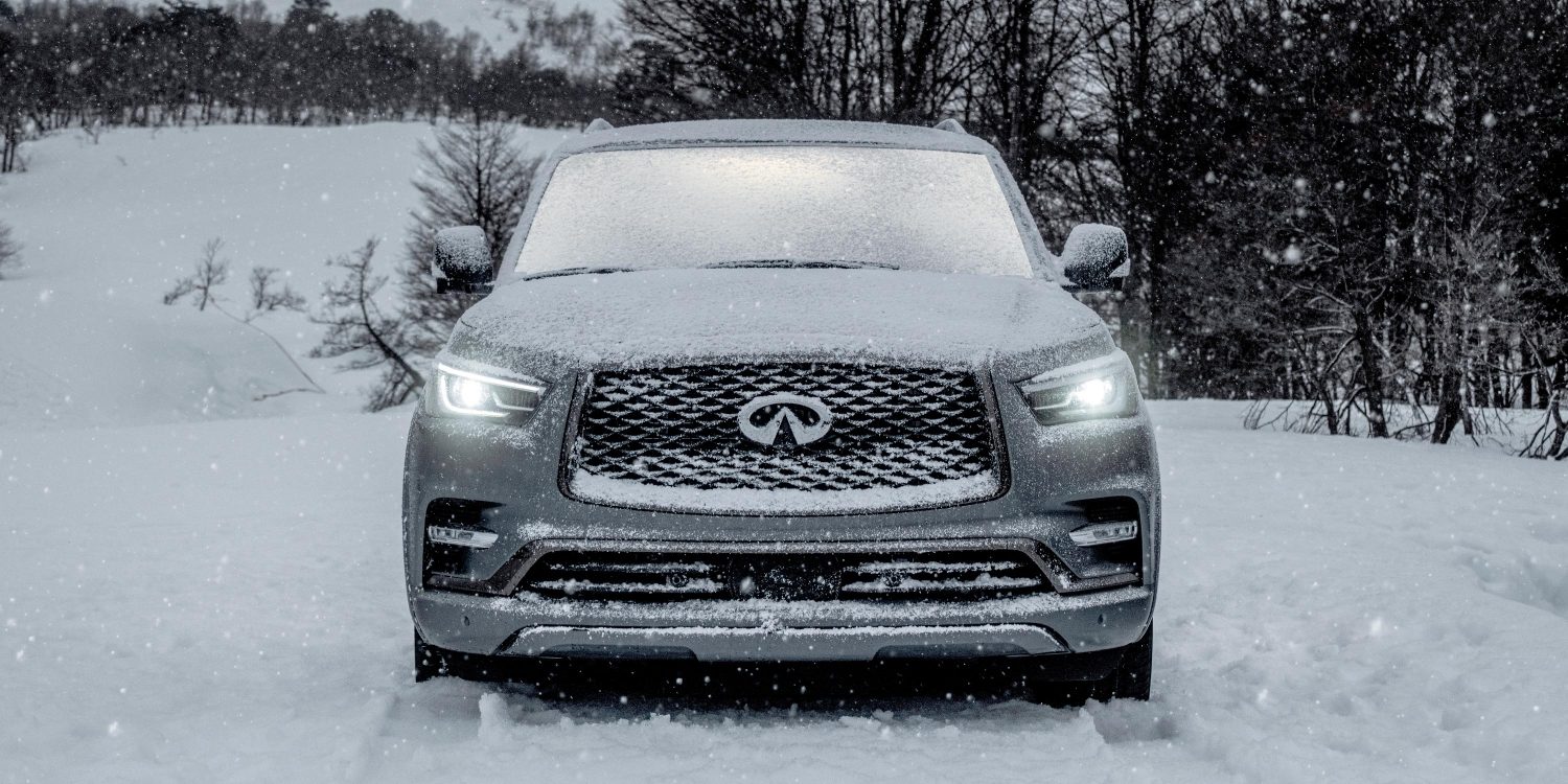 A luxury INFINITI SUV driving in snow