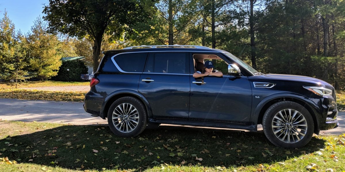 Side view of a parked blue INFINITI QX80.
