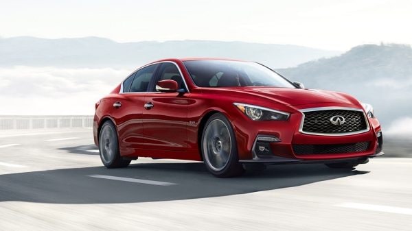 A red 2020 INFINITI Q50 driving fast on the road