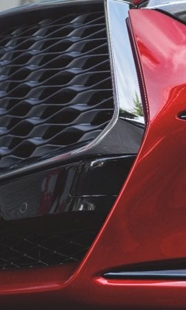 Mobile 428 x 926 wallpaper closeup image of a red QX55 Crossover Coupe's grill.