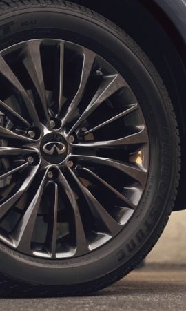 Mobile 428 x 926 wallpaper image of a QX80 Full-Size Luxury SUV's front tire rims.