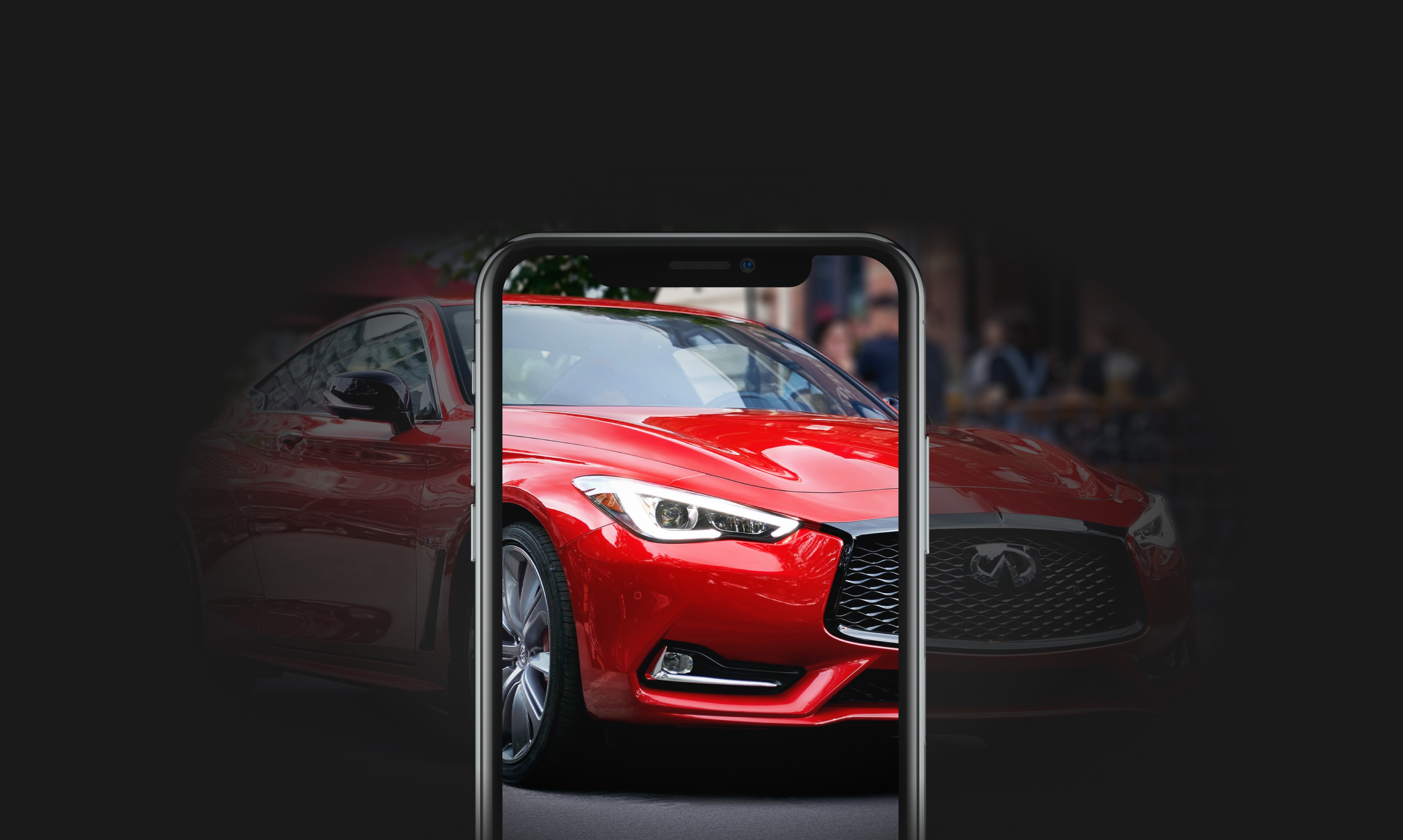 Front of a red Q60 Sport Coupe viewed through a phone screen on black background.