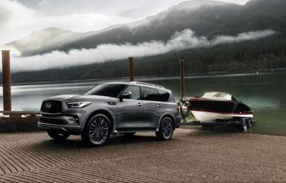 INFINITI QX80 towing a boat up a ramp.