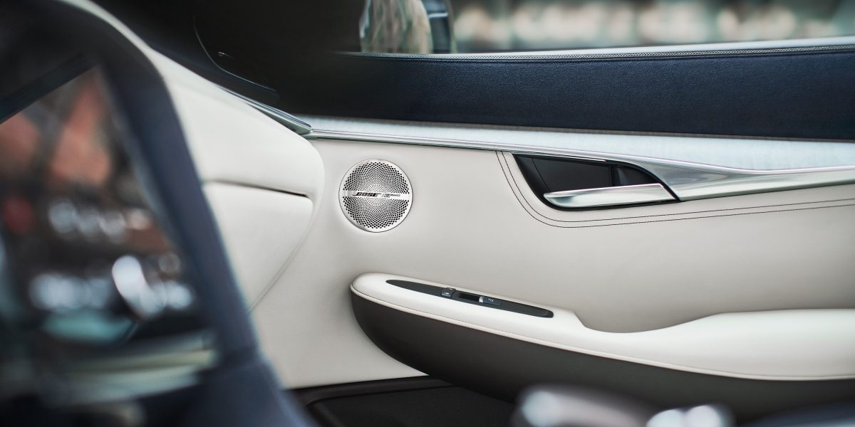 Bose speakers mounted on the white leather trim inside the door panel of an INFINITI's car stereo