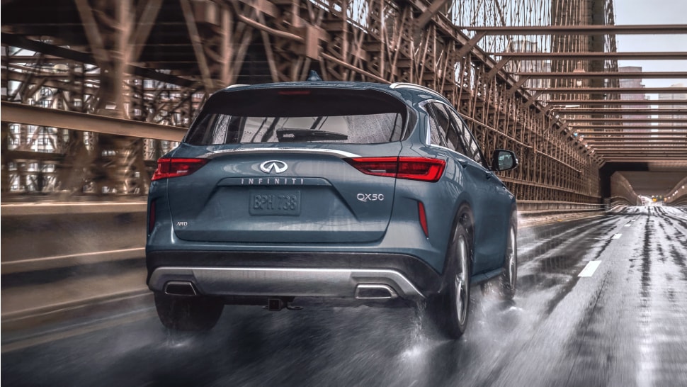 Rear view of 2024 INFINITI QX50 luxury crossover SUV driving through the street