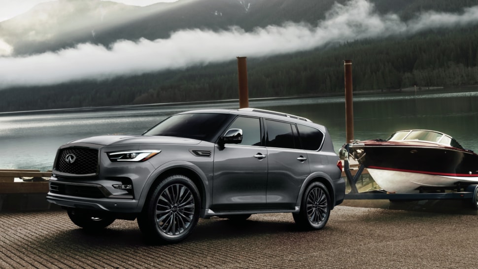 Side profile of 2024 INFINITI QX80 towing a boat highlighting towing capacity