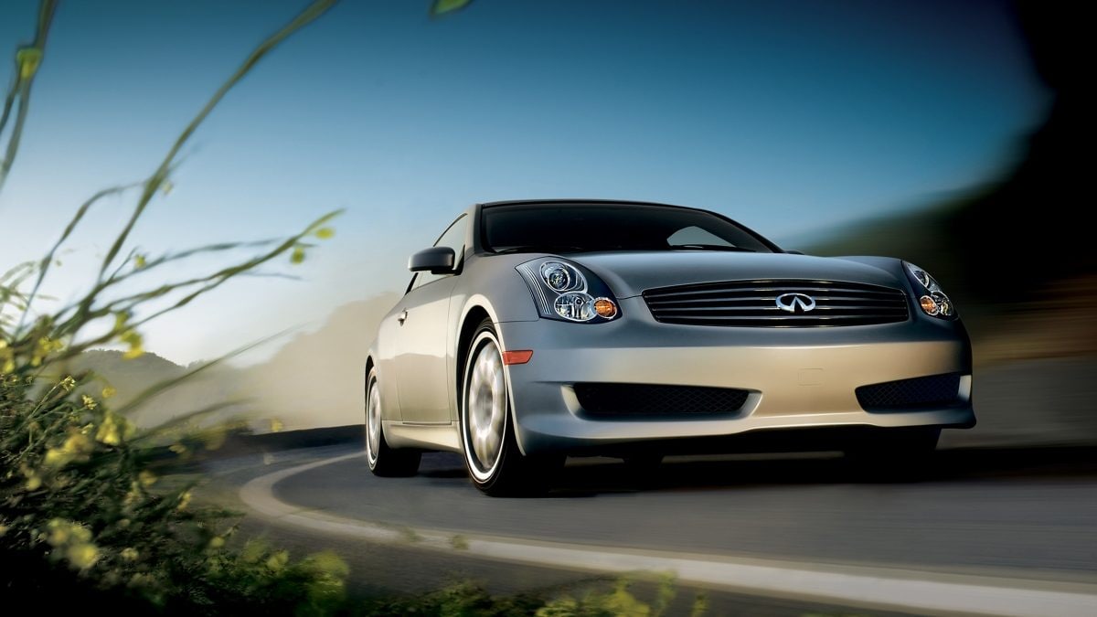Front profile of a silver INFINITI G35 driving on the road.