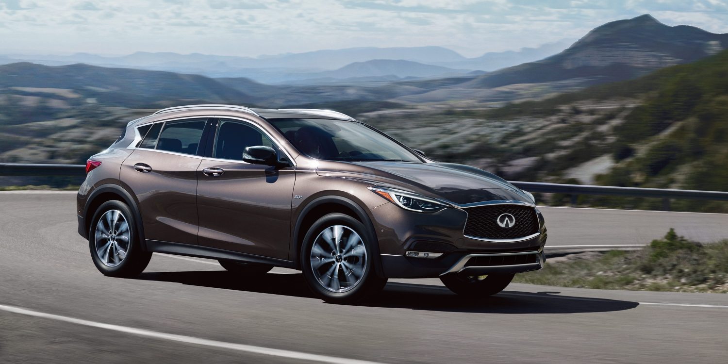 A side view of the INFINITI QX30 driving on a mountain highway
