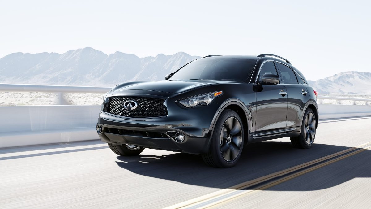 A view of the front of an INFINITI QX70 driving with mountains in the background
