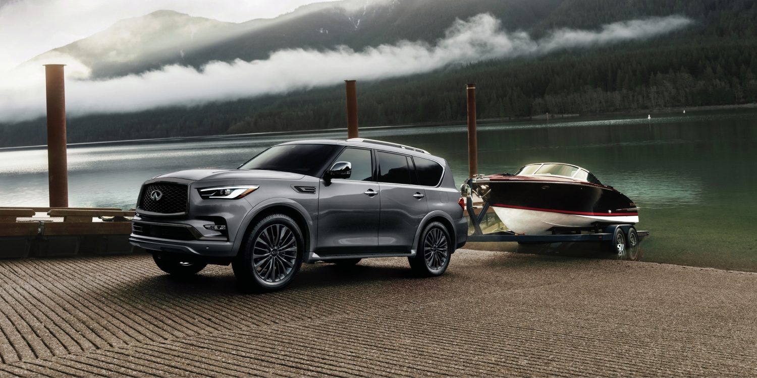 INFINITI QX80 towing a boat up a ramp.